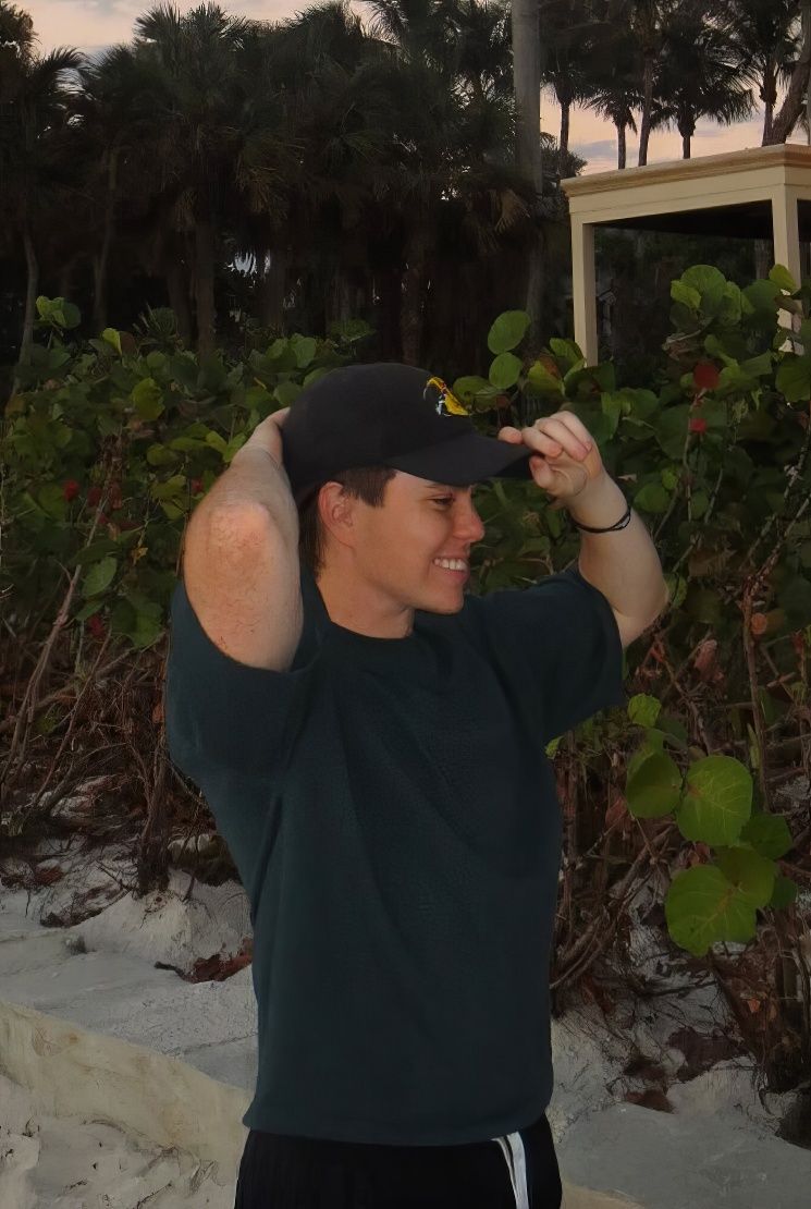 Jacob Hutiu on the beach in front of a house